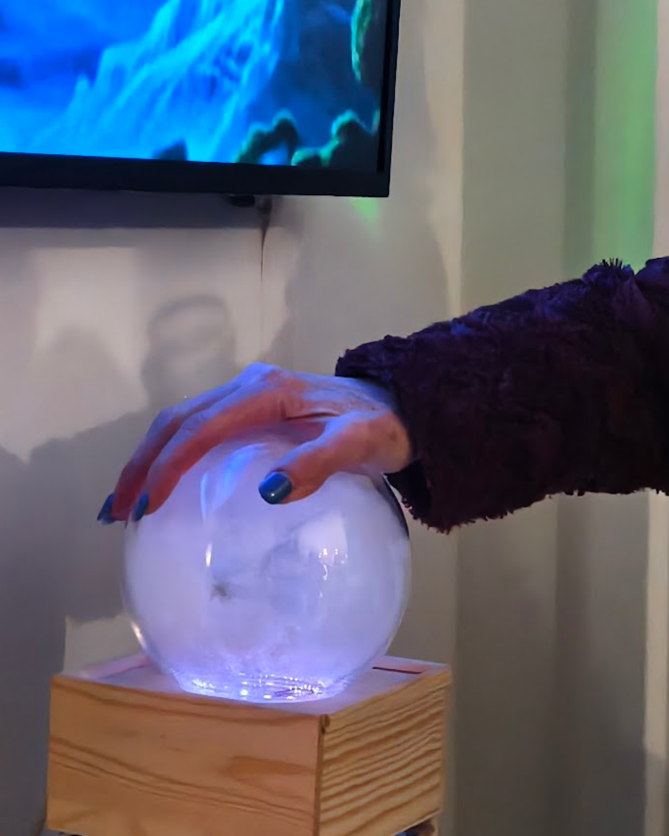 Detail of hands cradling Vibe Altar crystal ball during feminist text invocation